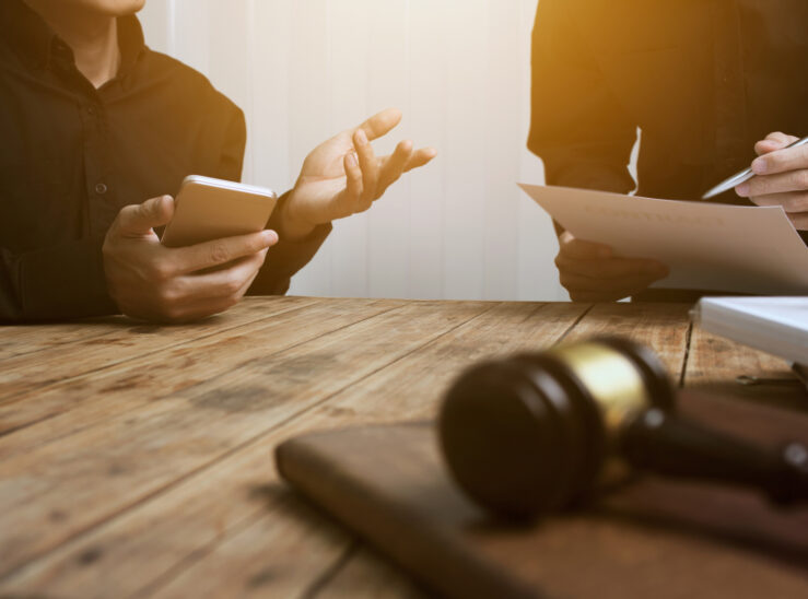 Two people talking with a gavel in the foreground